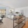 Open concept living room and office space with an abundance of natural light from large windows and Juliet style balcony